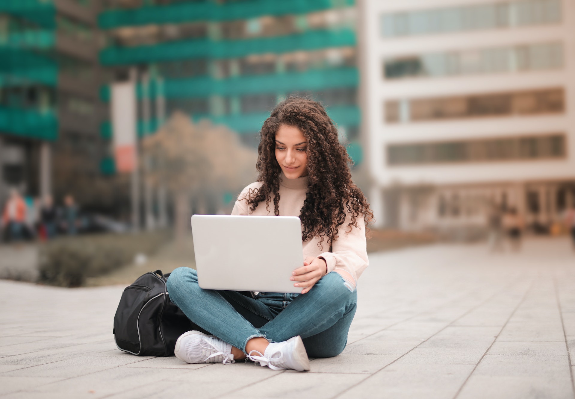 happy woman sitting with her laptop in her lap